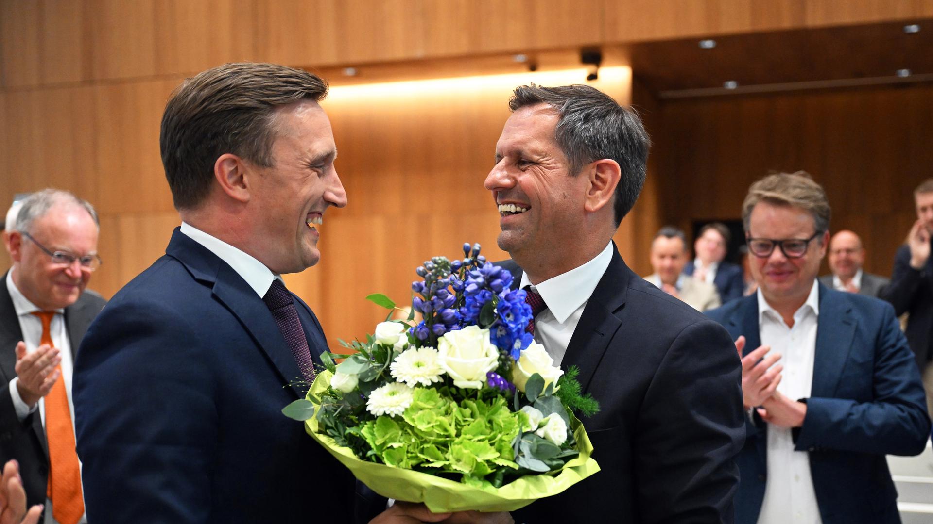 Olaf Lies (SPD, r) erhält nach seiner Wahl zum Ministerpräsidenten von Niedersachsen einen Blumenstrauß von Sebastian Lechner (CDU), Fraktionsvorsitzender seiner Partei im Niedersächsischen Landtag, während der Sitzung des Niedersächsischen Landtags. Olaf Lies (SPD, r) erhält nach seiner Wahl zum Ministerpräsidenten von Niedersachsen einen Blumenstrauß von Sebastian Lechner (CDU), Fraktionsvorsitzender seiner Partei im Niedersächsischen Landtag, während der Sitzung des Niedersächsischen Landtags.