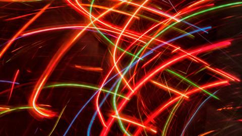 Wilde, bunte Lichterstreifen erscheinen vor einem dunklen Hintergrund. 