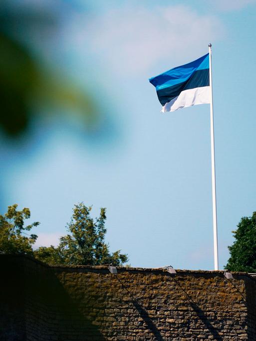 Auf der Burg Narwa in Estland weht eine estnische Flagge: drei gleich breite waagerechte Streifen in Blau, Schwarz und Weiß.