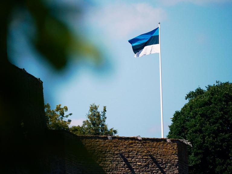 Auf der Burg Narwa in Estland weht eine estnische Flagge: drei gleich breite waagerechte Streifen in Blau, Schwarz und Weiß.