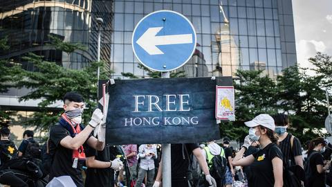Protestierende befestigen am 01.07.2019 ein Plakat mit der Aufschrift "Free Hongkong" an einem Verkehrsschild vor dem Legislativrat in Hongkong.