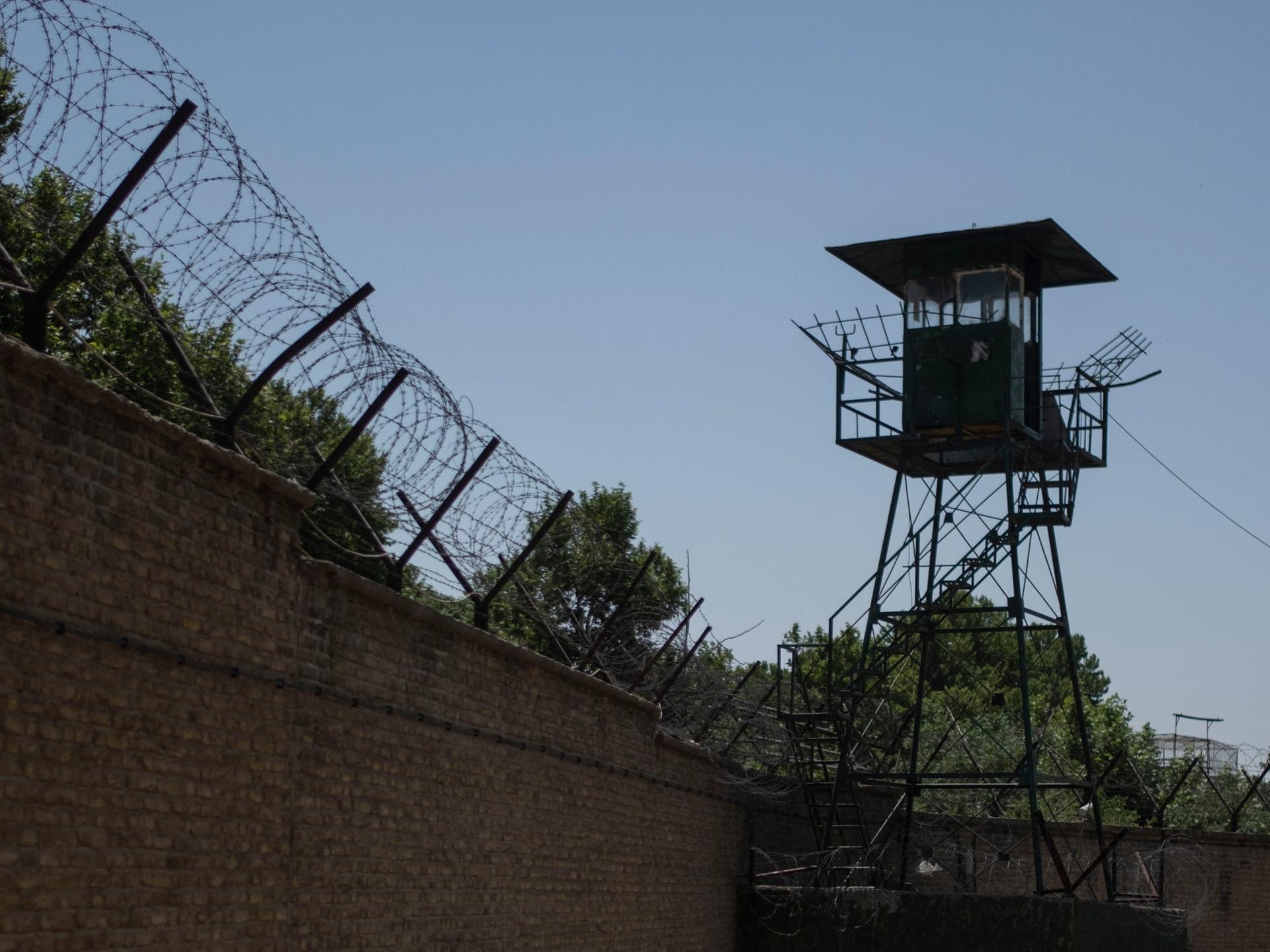 Mit Stacheldraht geschützte Außenmauer des Teheraner Evin-Gefängnisses sowie ein Wachturm.