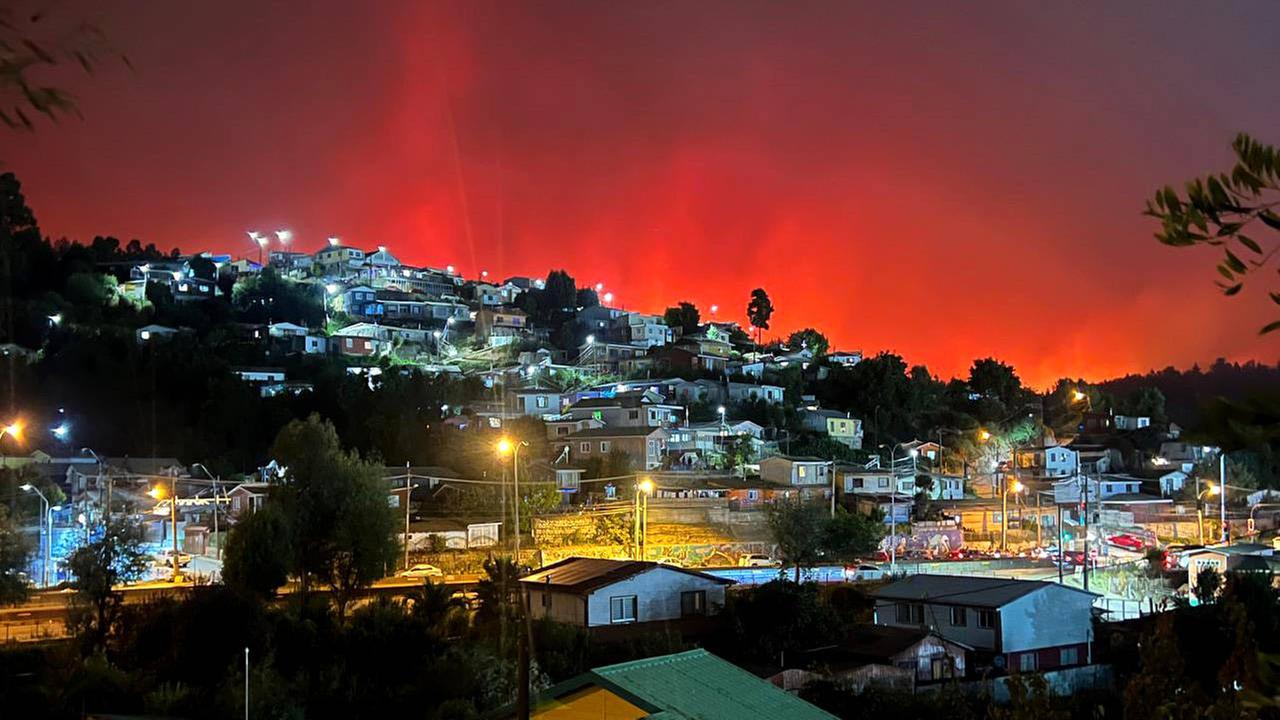 Das Foto zeigt einen rot erleuchteten Nachthimmer wegen eines Waldbrandes in der Stadt Concepcion in Chile.