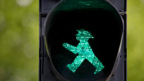 Fußgängerampel mit grünem Ampelmännchen.