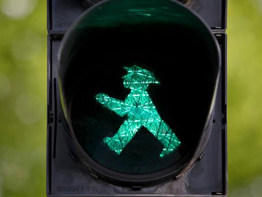 Fußgängerampel mit grünem Ampelmännchen.