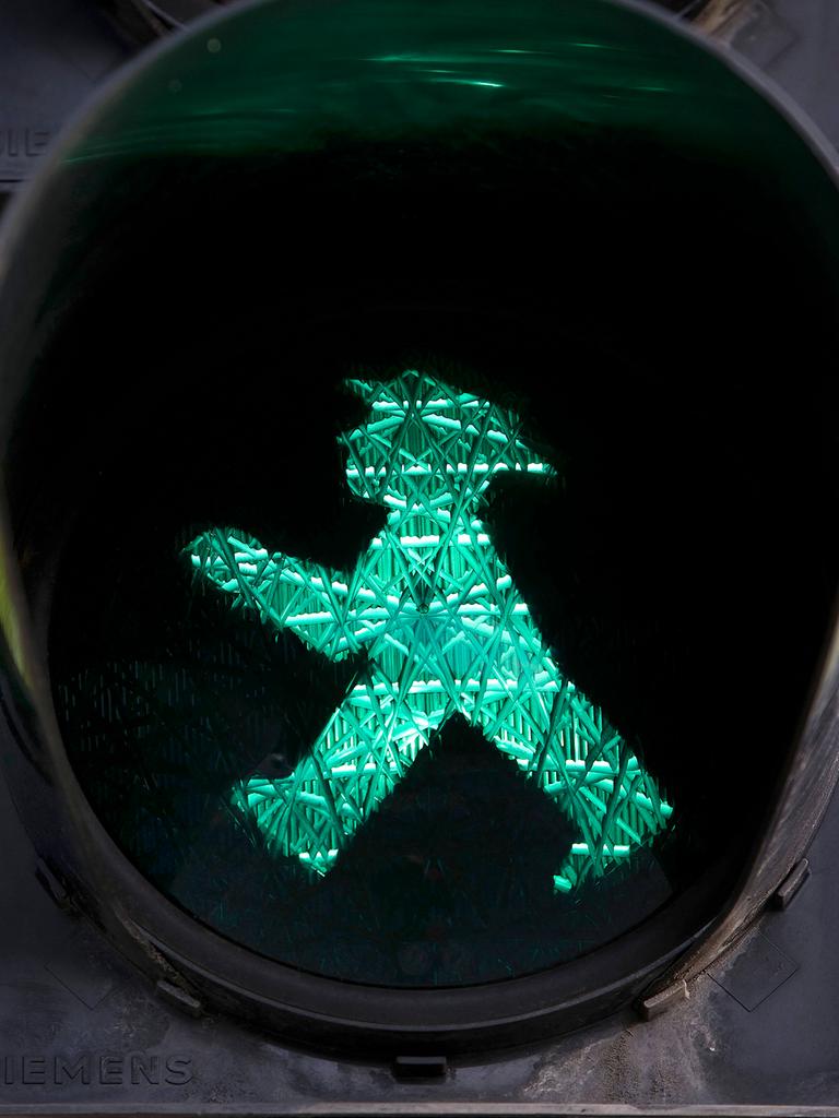 Fußgängerampel mit grünem Ampelmännchen.