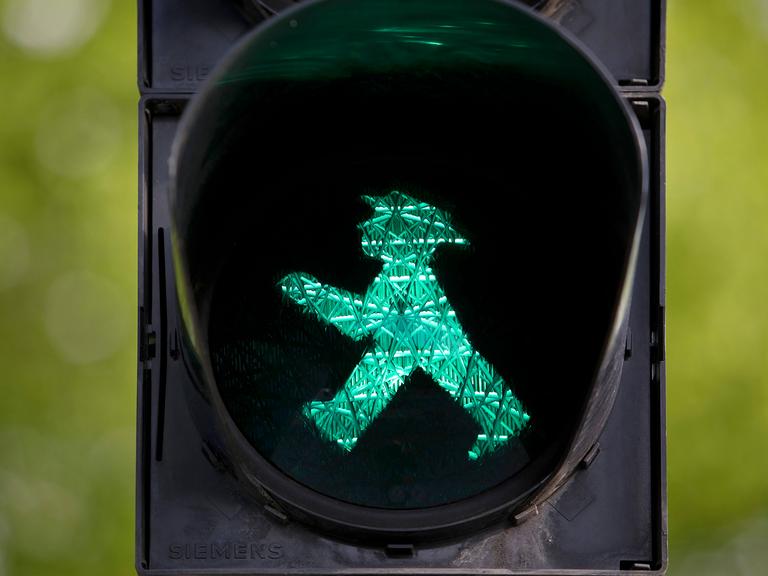 Fußgängerampel mit grünem Ampelmännchen.