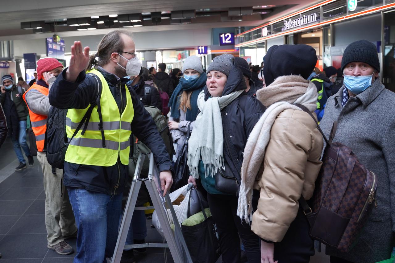Der freiwillige Helfer Marcel, ein Ingenieur in Elternzeit, sagt am Berliner Hauptbahnhof gerade angekommenen Flüchtlingen, wie sie ins Landesamt für Flüchtlingsangelegenheiten (LAF) kommen oder wie sie einen Bahnfahrschein für die Weiterfahrt erhalten. 