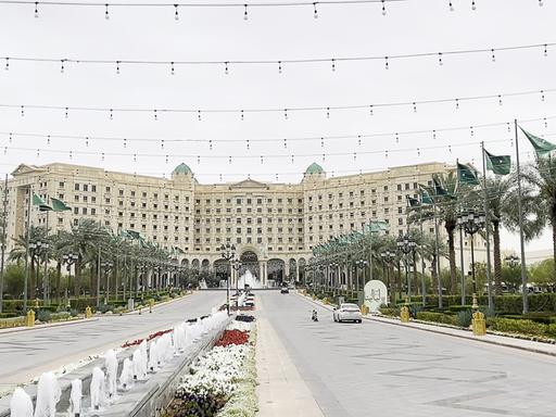 Das Foto zeigt eine Straße, die auf ein großes Gebäude zuführt. Links und rechts stehen Palmen.
DIESES FOTO WIRD VON DER RUSSISCHEN STAATSAGENTUR TASS ZUR VERFÜGUNG GESTELLT.