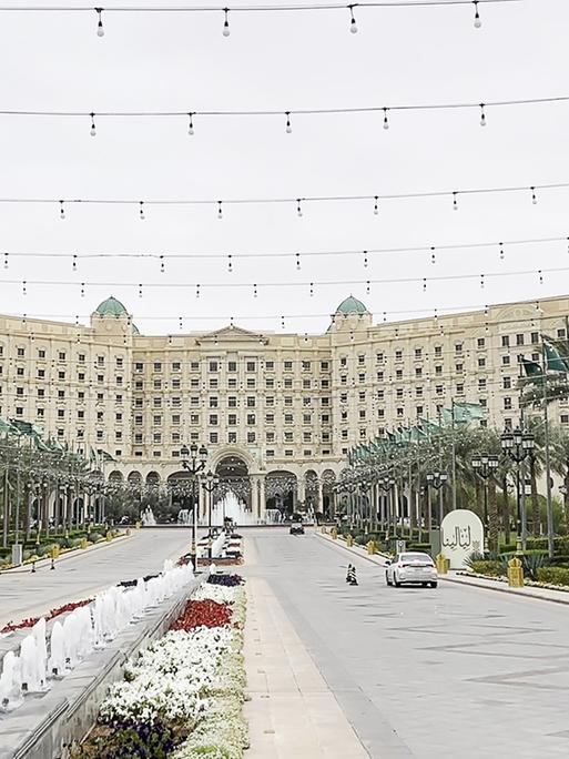 Das Foto zeigt eine Straße, die auf ein großes Gebäude zuführt. Links und rechts stehen Palmen.
DIESES FOTO WIRD VON DER RUSSISCHEN STAATSAGENTUR TASS ZUR VERFÜGUNG GESTELLT.