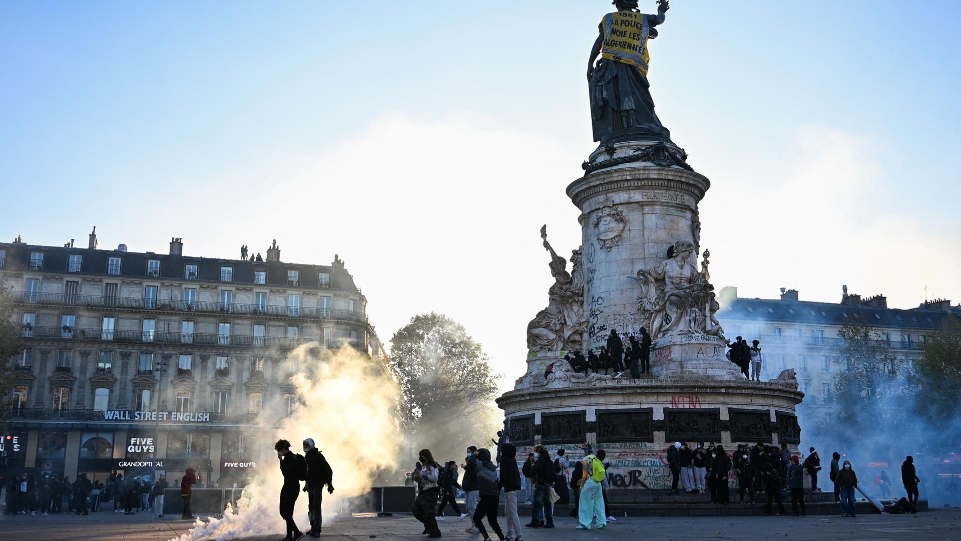 Demonstranten stehen im Abendlicht auf dem Platz der Republik im Zentrum von Paris.