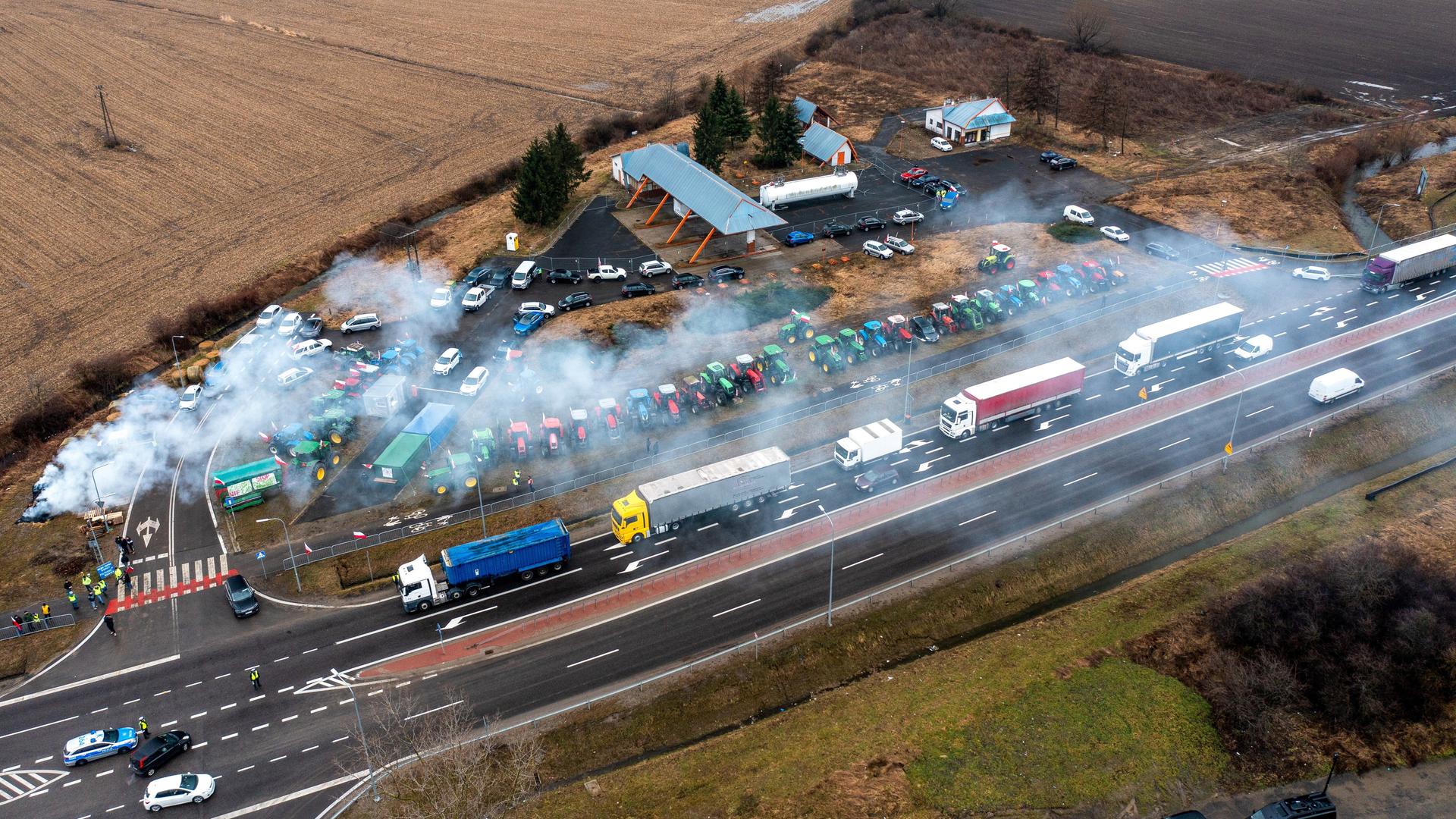 Luftaufnahme: Lastwagen und Traktoren blockieren einen Grenzübergang. Luftaufnahme: Lastwagen und Traktoren blockieren einen Grenzübergang.