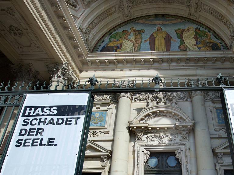 Transparente mit der Aufschrift "Hass schadet der Seele" und "Hate harms the soul" am Eingang des Berliner Doms.