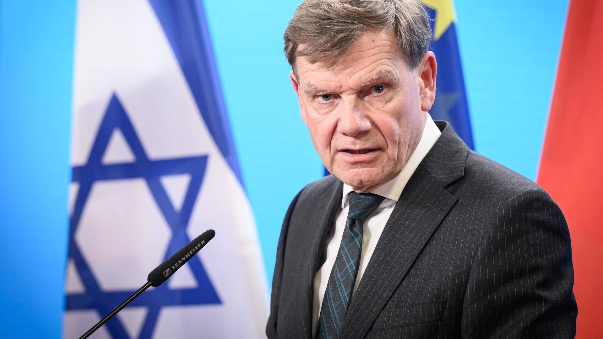 Außenminister Johann Wadephul mit den Flaggen von Israel, der EU und Deutschland