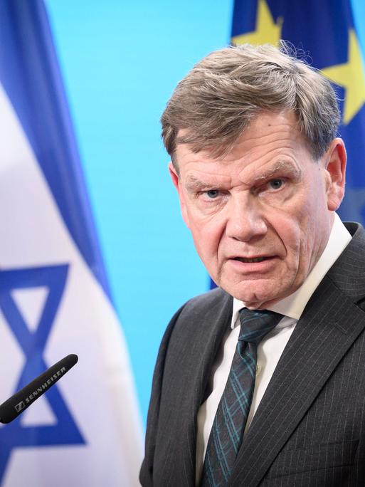 Außenminister Johann Wadephul mit den Flaggen von Israel, der EU und Deutschland