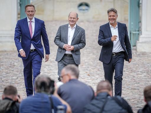 Finanzminister Christian Lindner, Bundeskanzler Olaf Scholz (SPD) und Wirtschaftsminister Robert Habeck auf der Pressekonferenz bei der Halbzeit-Klausur des Bundeskabinetts vor Schloss Meseberg.