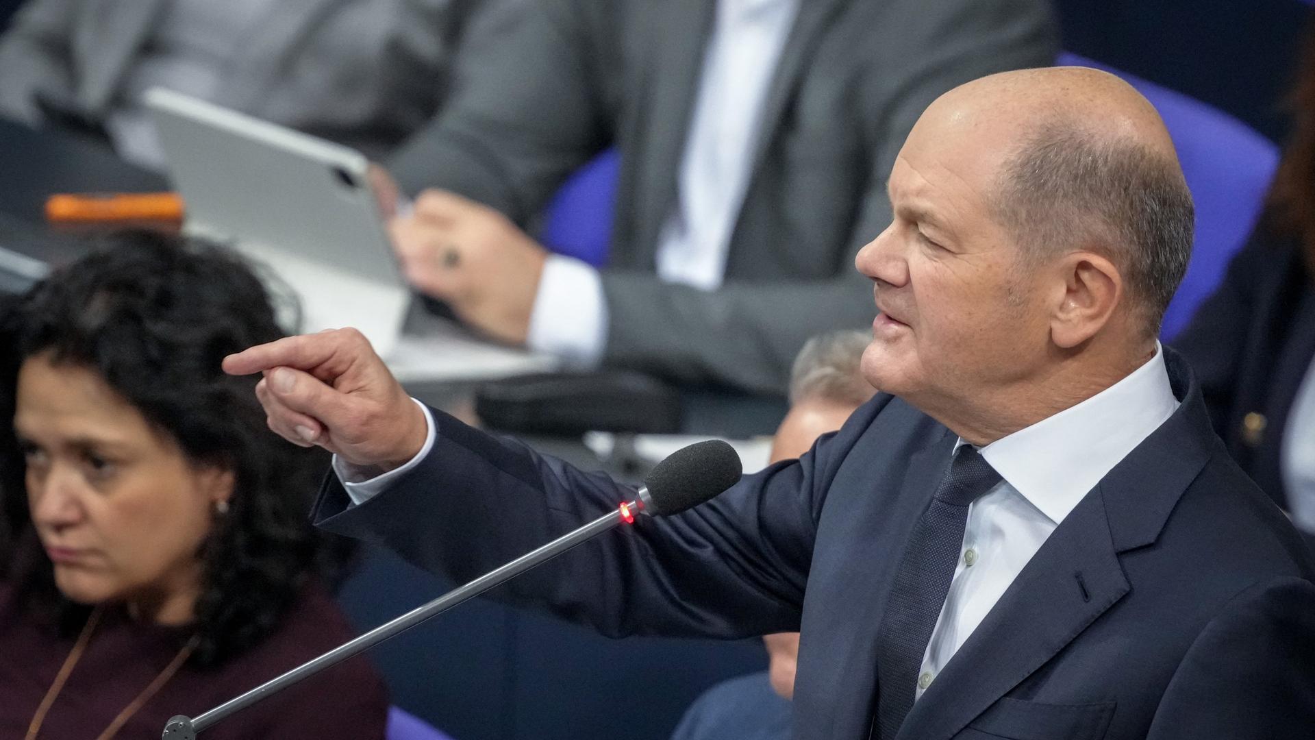 Bundeskanzler Olaf Scholz nimmt an der Befragung der Bundesregierung im Plenarsaal im Bundestag teil und gestikuliert.