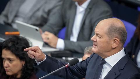 Bundeskanzler Olaf Scholz nimmt an der Befragung der Bundesregierung im Plenarsaal im Bundestag teil und gestikuliert.