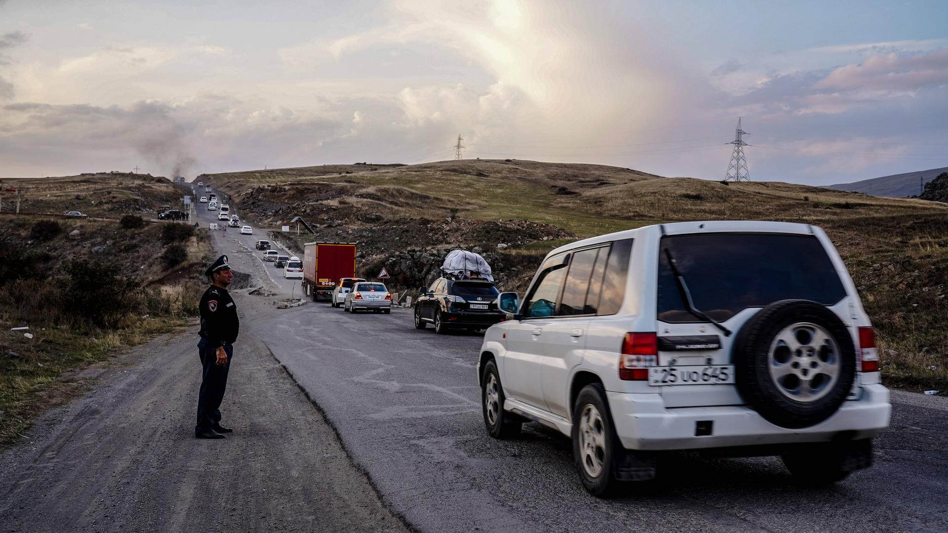 29. September 2023, in der Nähe von Goris, Armenien: Eine Reihe von Autos, teils voller persönlicher Gegenstände, stehen entlang der Autobahn nach Armenien. 