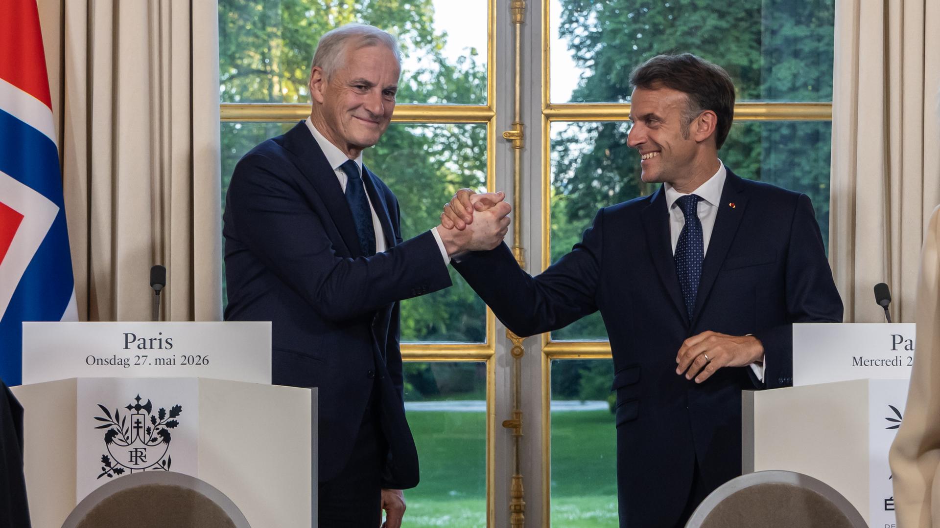 Frankreich, Paris: Emmanuel Macron (r), Präsident von Frankreich, und Jonas Gahr Støre, Ministerpräsident von Norwegen, geben sich während einer gemeinsamen Pressekonferenz im Elysee-Palast die Hand. 