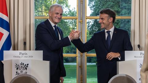 Frankreich, Paris: Emmanuel Macron (r), Präsident von Frankreich, und Jonas Gahr Støre, Ministerpräsident von Norwegen, geben sich während einer gemeinsamen Pressekonferenz im Elysee-Palast die Hand. 