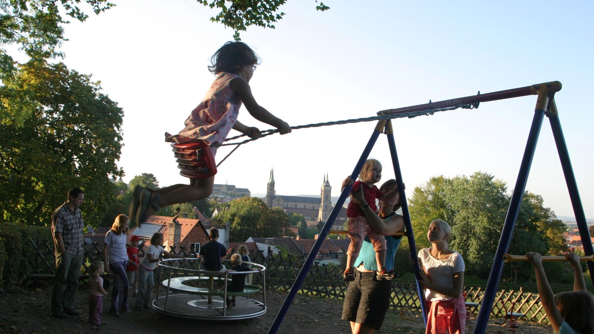 Kinder schaukeln und spielen auf einem Spielplatz Kinder schaukeln und spielen auf einem Spielplatz