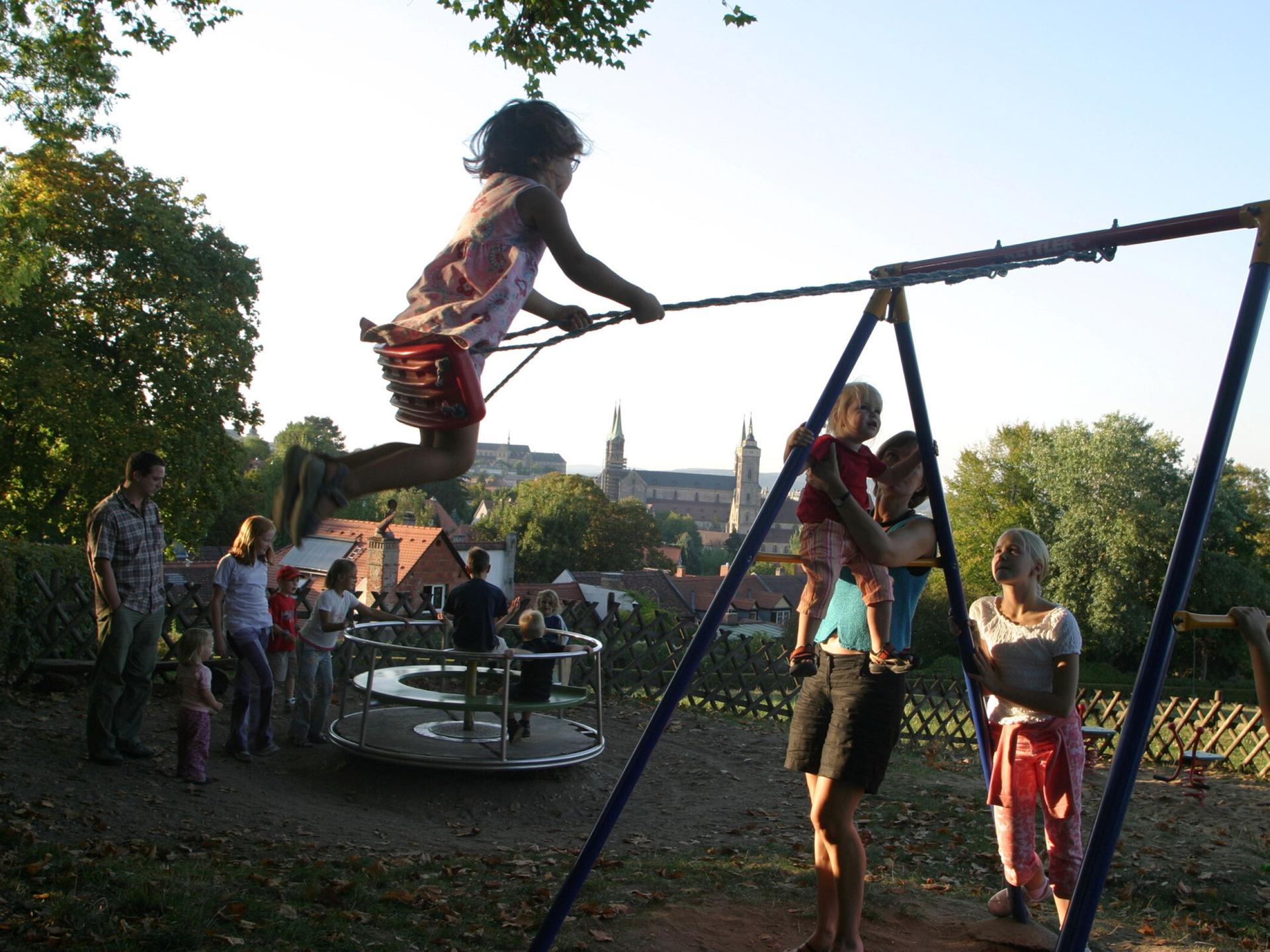 Kinder schaukeln und spielen auf einem Spielplatz