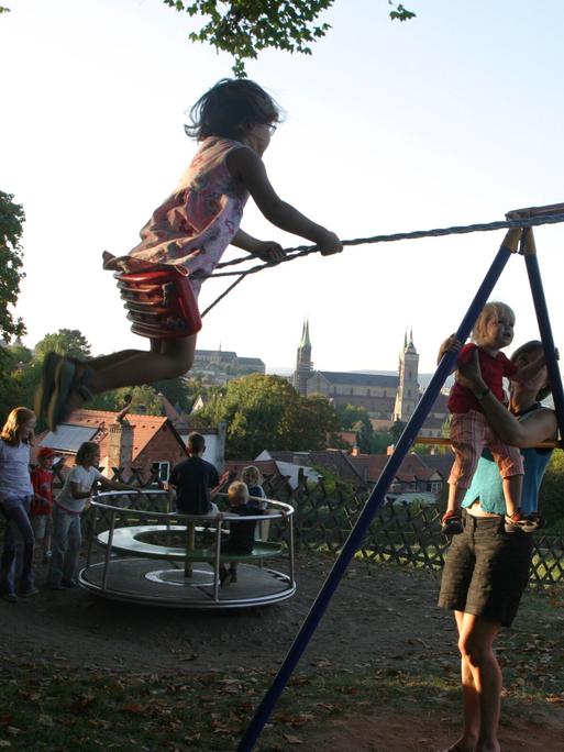 Kinder schaukeln und spielen auf einem Spielplatz