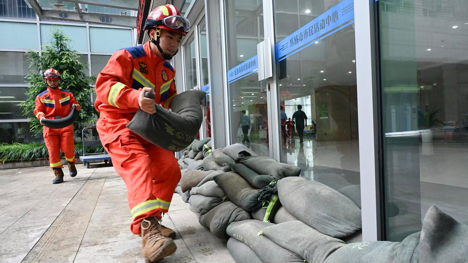 Feuerwehrleute in China legen in der Provinz Zhejiang Sandsäcke aus, um Fenster und Türen vor dem herannahenden Taifun Bavi zu sichern. Feuerwehrleute in China legen in der Provinz Zhejiang Sandsäcke aus, um Fenster und Türen vor dem herannahenden Taifun Bavi zu sichern.