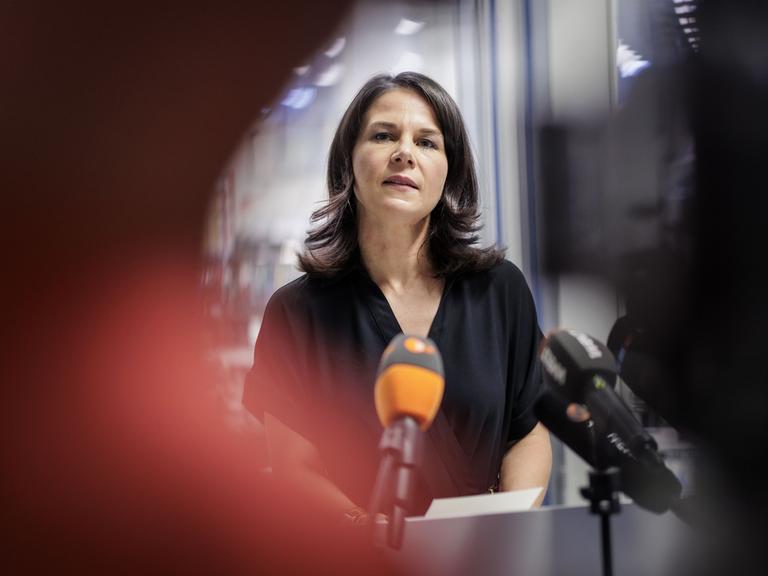 Bundesaußenministerin Annalena Baerbock steht hinter einem Pult mit Mikrofonen