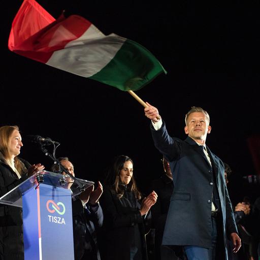 Peter Magyar schwenkt nach seinem Wahlsieg am 13. April 2026 eine ungarische Flagge.