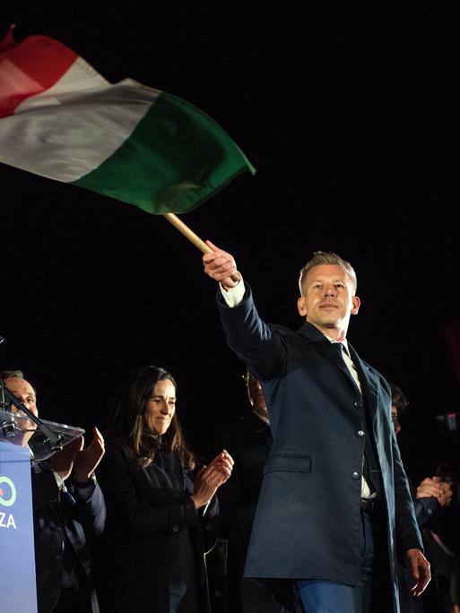 Peter Magyar schwenkt nach seinem Wahlsieg am 13. April 2026 eine ungarische Flagge.