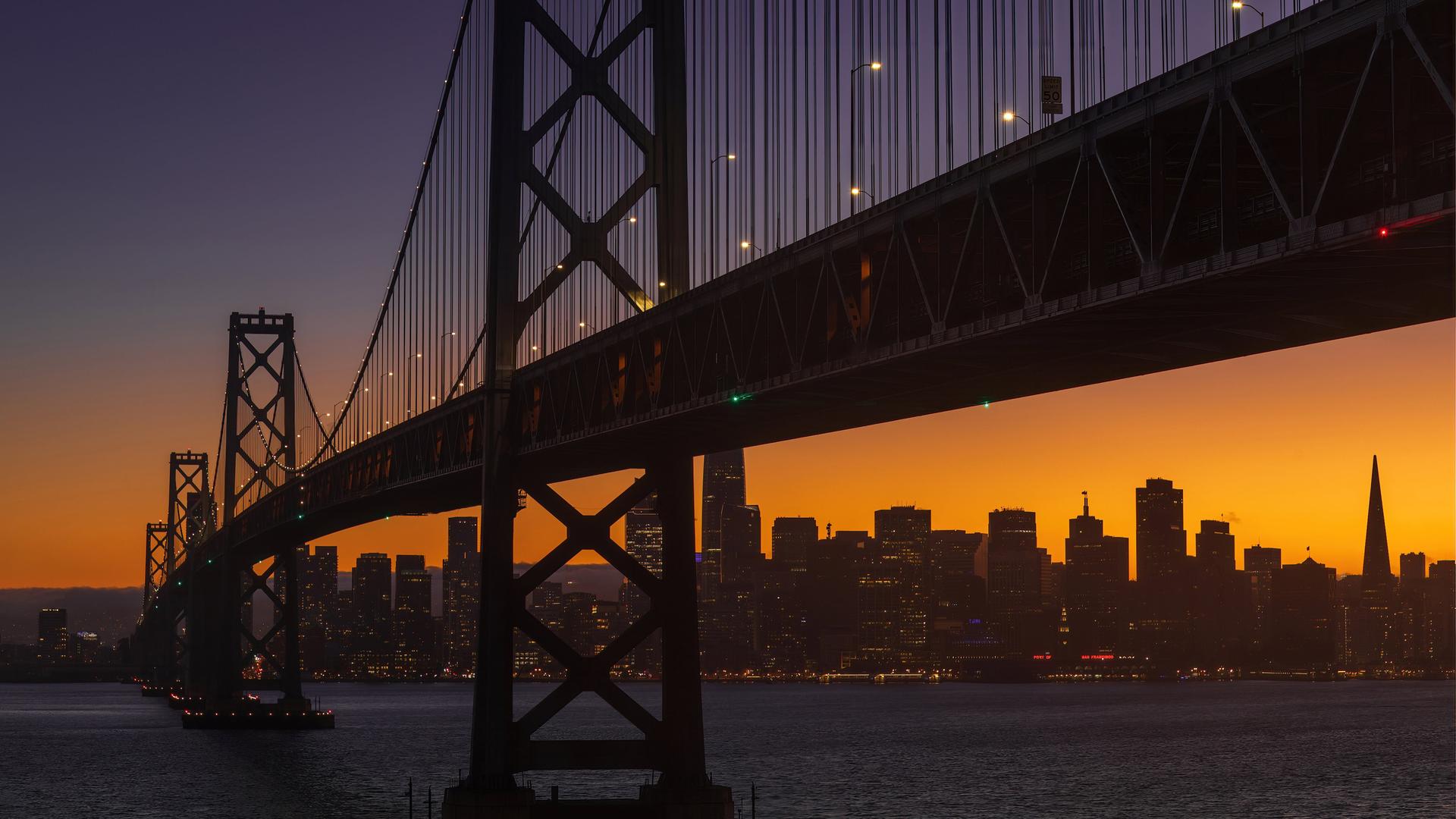 Die Bay Bridge am frühen Abend in San Francisco. Im Hintergrund geht die Sonne unter.  Die Bay Bridge am frühen Abend in San Francisco. Im Hintergrund geht die Sonne unter.