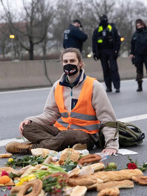 Klimaaktivisten bei einer Autobahnblockade, sie sitzen auf dem Aspalt und haben sich mit Sekundenkleber die Hände am Boden festgeklebt, 04.02.2022.