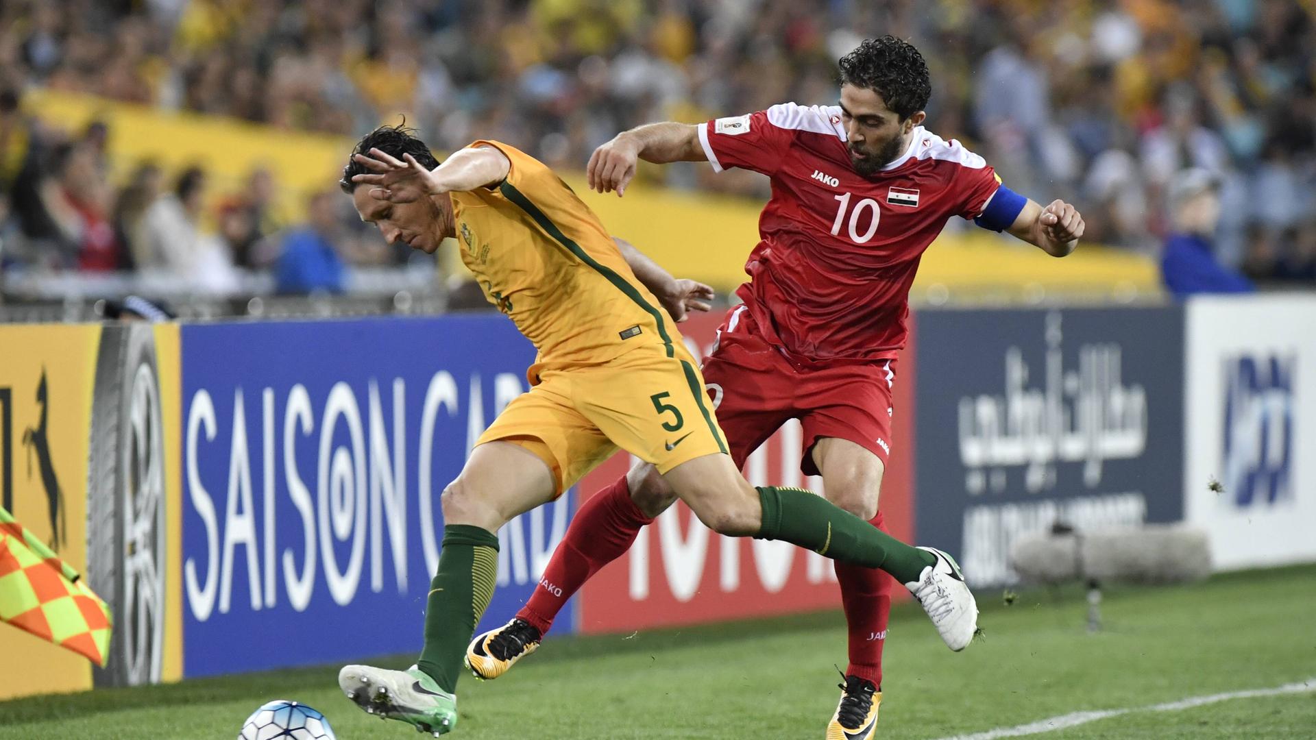 Der australische Mittelfeldspieler Mark Milligan greift den syrischen Nationalstürmer Firas al-Khatib während eines WM-Qualifiktationsspiels an