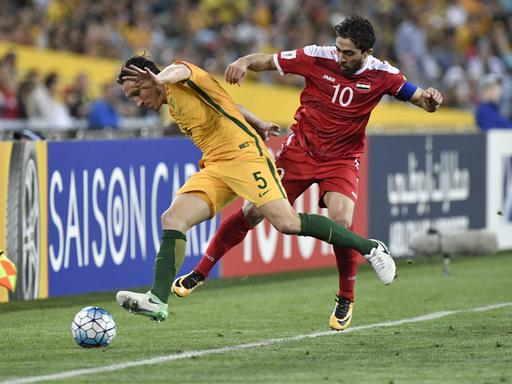 Der australische Mittelfeldspieler Mark Milligan greift den syrischen Nationalstürmer Firas al-Khatib während eines WM-Qualifiktationsspiels an