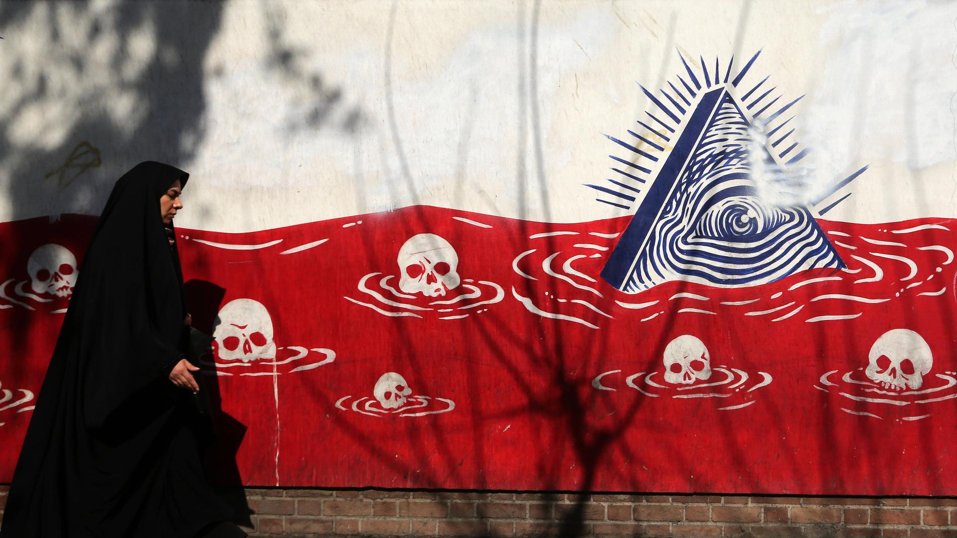 Daily life in Iran TEHRAN, IRAN - JANUARY 28: A woman walks past an anti-American murals following a possible US intervention against Iran on January 28, 2026 in Tehran, Iran. 