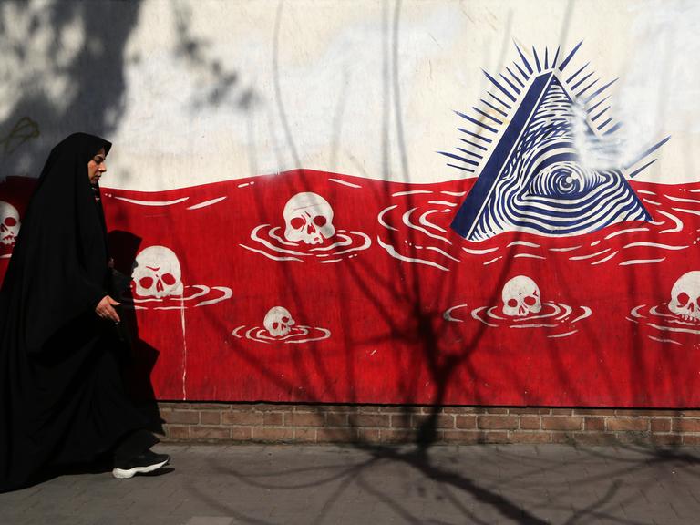Daily life in Iran TEHRAN, IRAN - JANUARY 28: A woman walks past an anti-American murals following a possible US intervention against Iran on January 28, 2026 in Tehran, Iran. 
