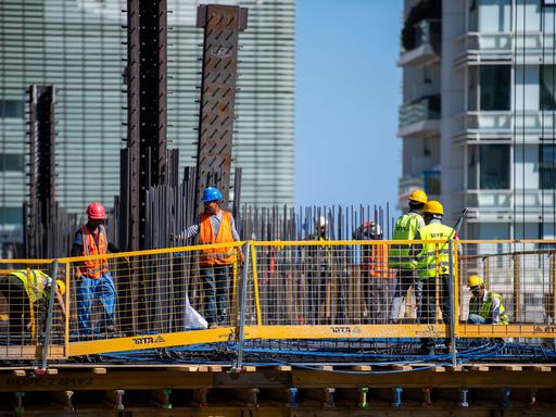 Bauarbeiter arbeiten auf einem Hausdach in Tel Aviv, Israel.