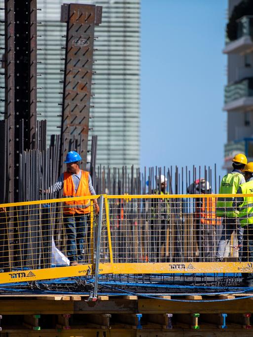 Bauarbeiter arbeiten auf einem Hausdach in Tel Aviv, Israel.