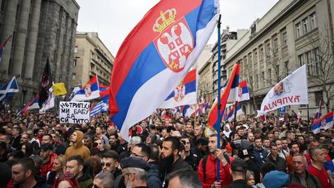 Zehntausende Menschen protestieren in Belgrad gegen die Regierung. Viele halten Transparente hoch.