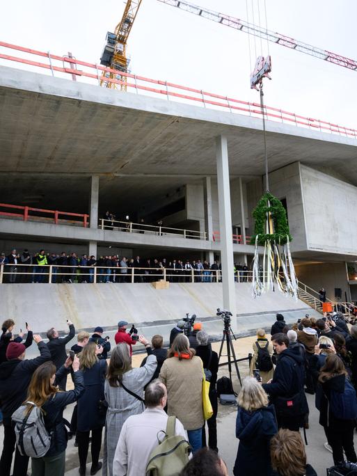 Der Richtkranz beim Richtfest für den Neubau des Museums Berlin Modern am Kulturforum in Berlin-Tiergarten von einem Kran hochgezogen. 