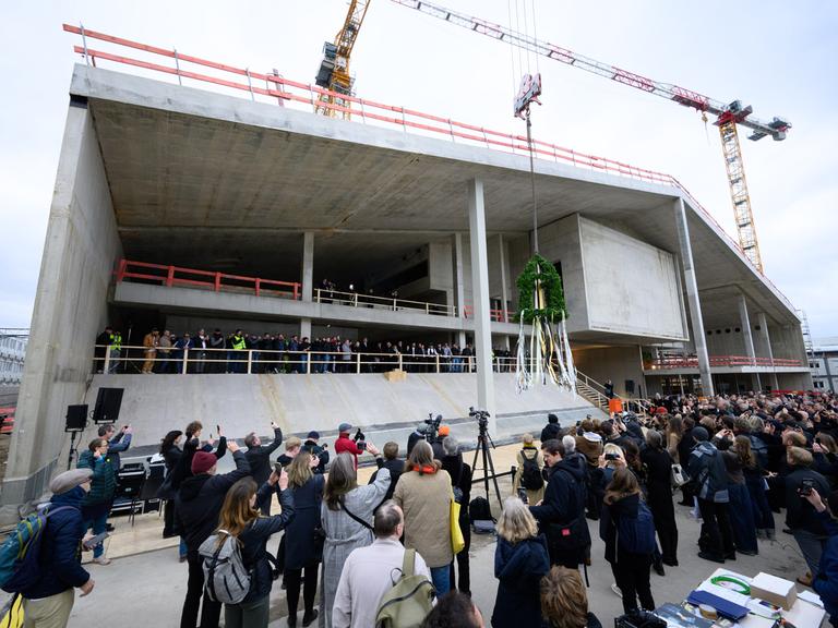 Der Richtkranz beim Richtfest für den Neubau des Museums Berlin Modern am Kulturforum in Berlin-Tiergarten von einem Kran hochgezogen. 