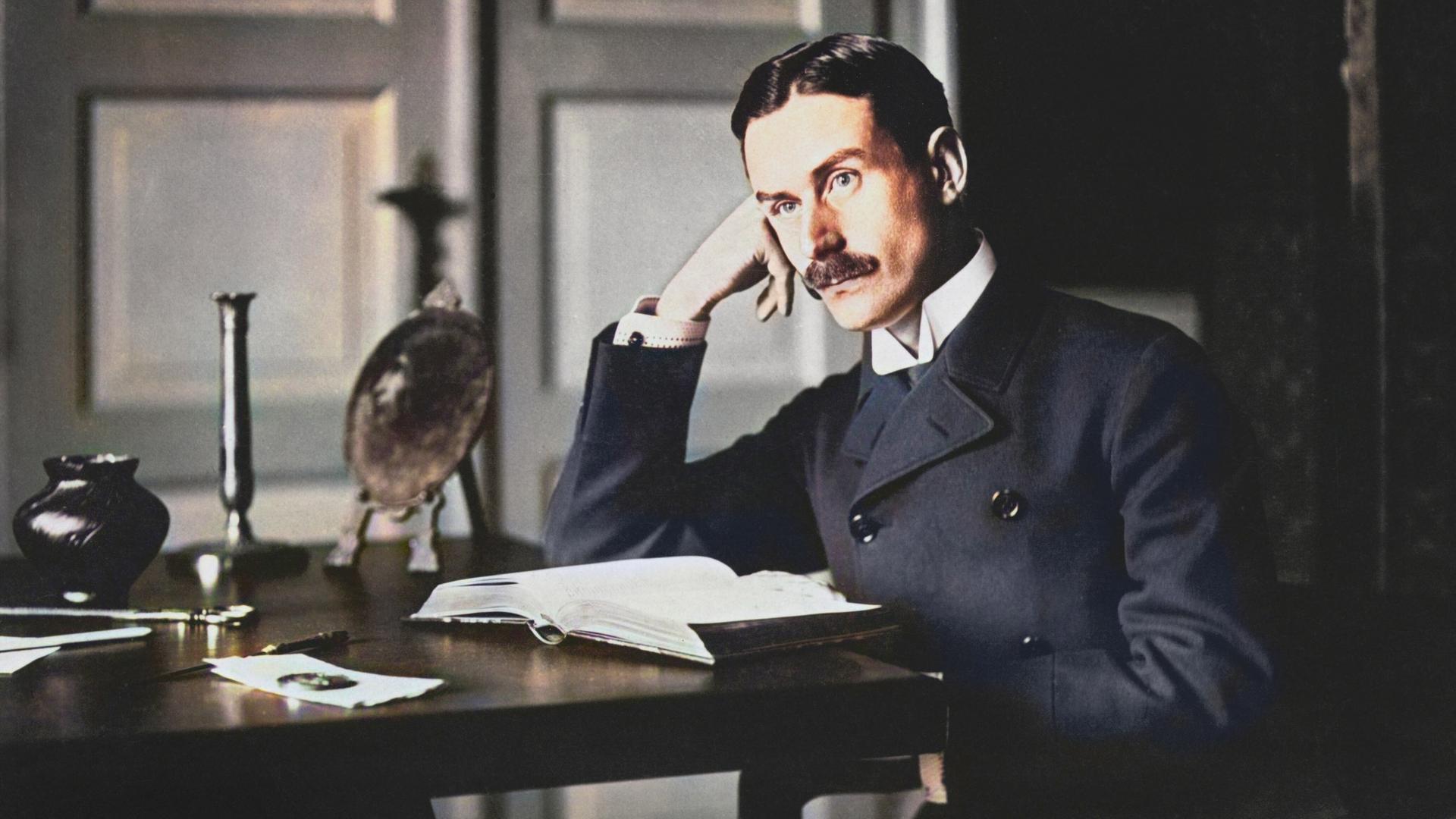 Thomas Mann sitzt an einem Tisch, den Kopf dabei in Hand gestützt. Nachkolorierte Fotografie. Thomas Mann sitzt an einem Tisch, den Kopf dabei in Hand gestützt. Nachkolorierte Fotografie.