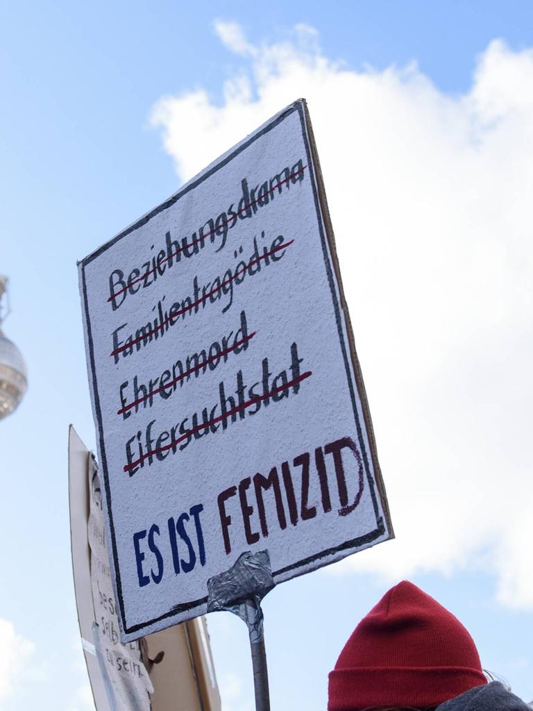 Demonstration am 8. März anlässlich des Internationalen Frauentags in Berlin. Im Bild ist ein Schild mit der Aufschrift Beziehungsdrama, Familientragödie, Ehrenmord, Eifersuchstat - es ist femizid und im Hintergrund der Fernsehturm zu sehen. 