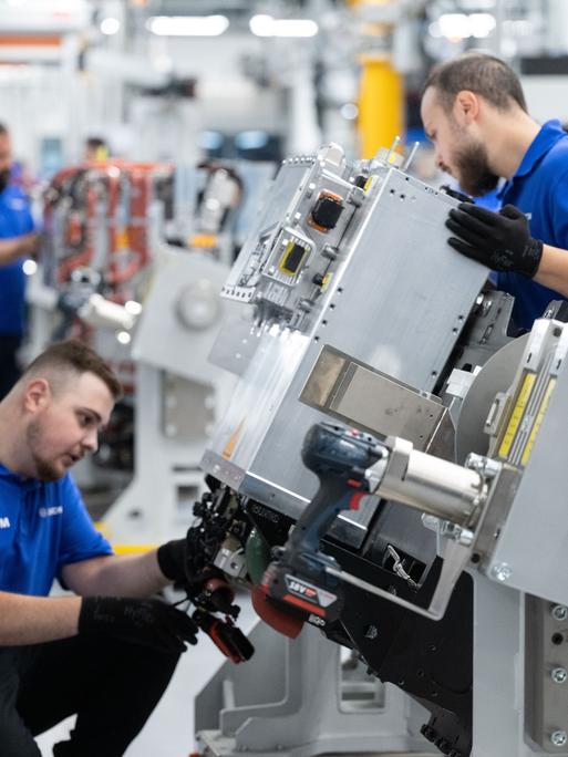 Mitarbeiter der Robert Bosch GmbH montieren in der Fertigung Brennstoffzellen-Antriebssysteme für die Stromerzeugung aus Wasserstoff in Fahrzeugen.