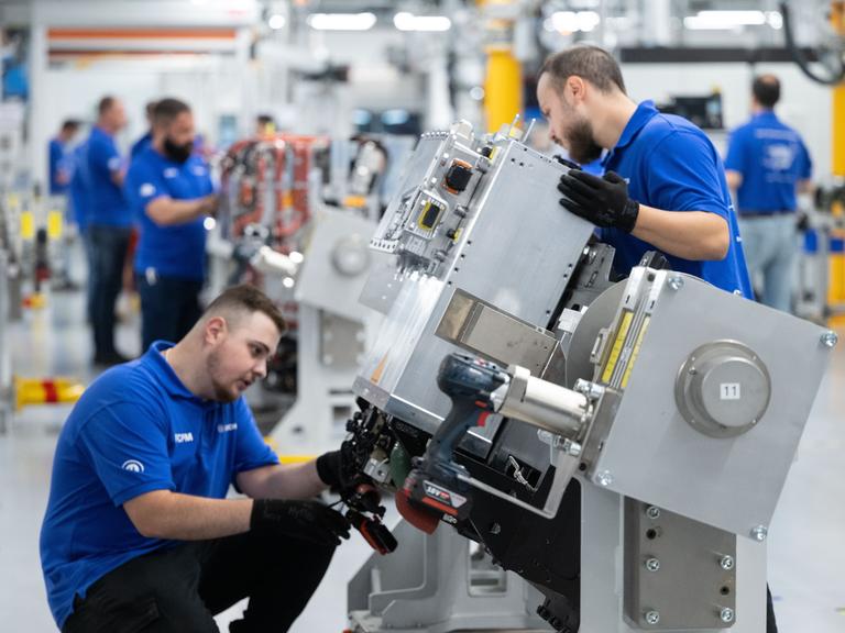 Mitarbeiter der Robert Bosch GmbH montieren in der Fertigung Brennstoffzellen-Antriebssysteme für die Stromerzeugung aus Wasserstoff in Fahrzeugen.