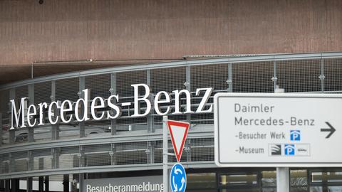 Ein Schriftzug mit der Aufschrift "Mercedes-Benz" prangt am Stammsitz des Automobilherstellers vor dem Werkseingang.