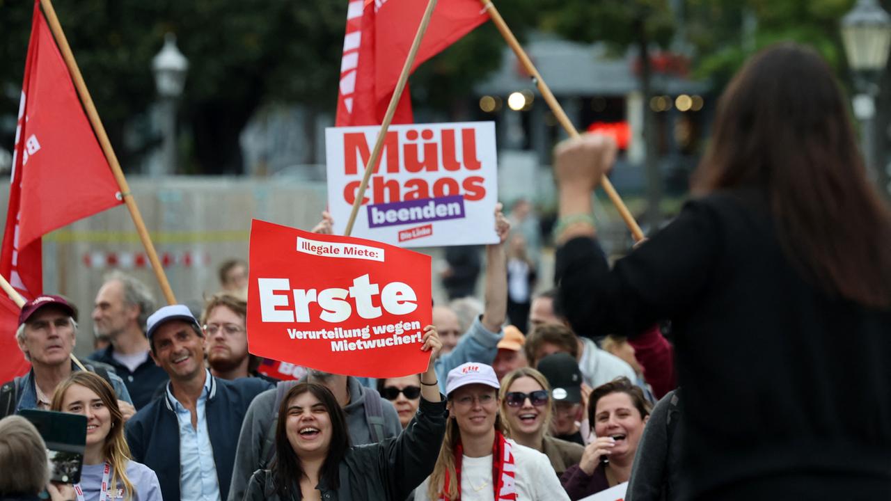 Elif Eralp steht während einer Wahlkampfveranstaltung mit erhobener Faust auf der Bühne. Vor ihr steht Publikum mit Bannern und Flaggen. 