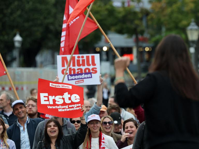 Elif Eralp steht während einer Wahlkampfveranstaltung mit erhobener Faust auf der Bühne. Vor ihr steht Publikum mit Bannern und Flaggen. Elif Eralp steht während einer Wahlkampfveranstaltung mit erhobener Faust auf der Bühne. Vor ihr steht Publikum mit Bannern und Flaggen.
